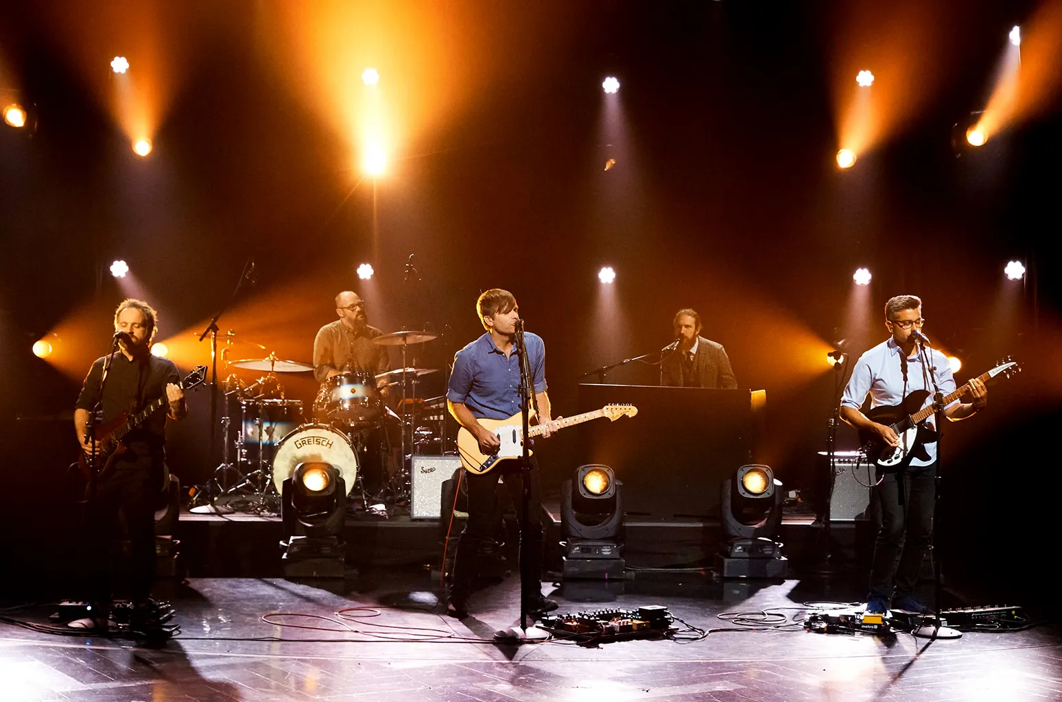 Death Cab for Cutie performing live under warm stage lights